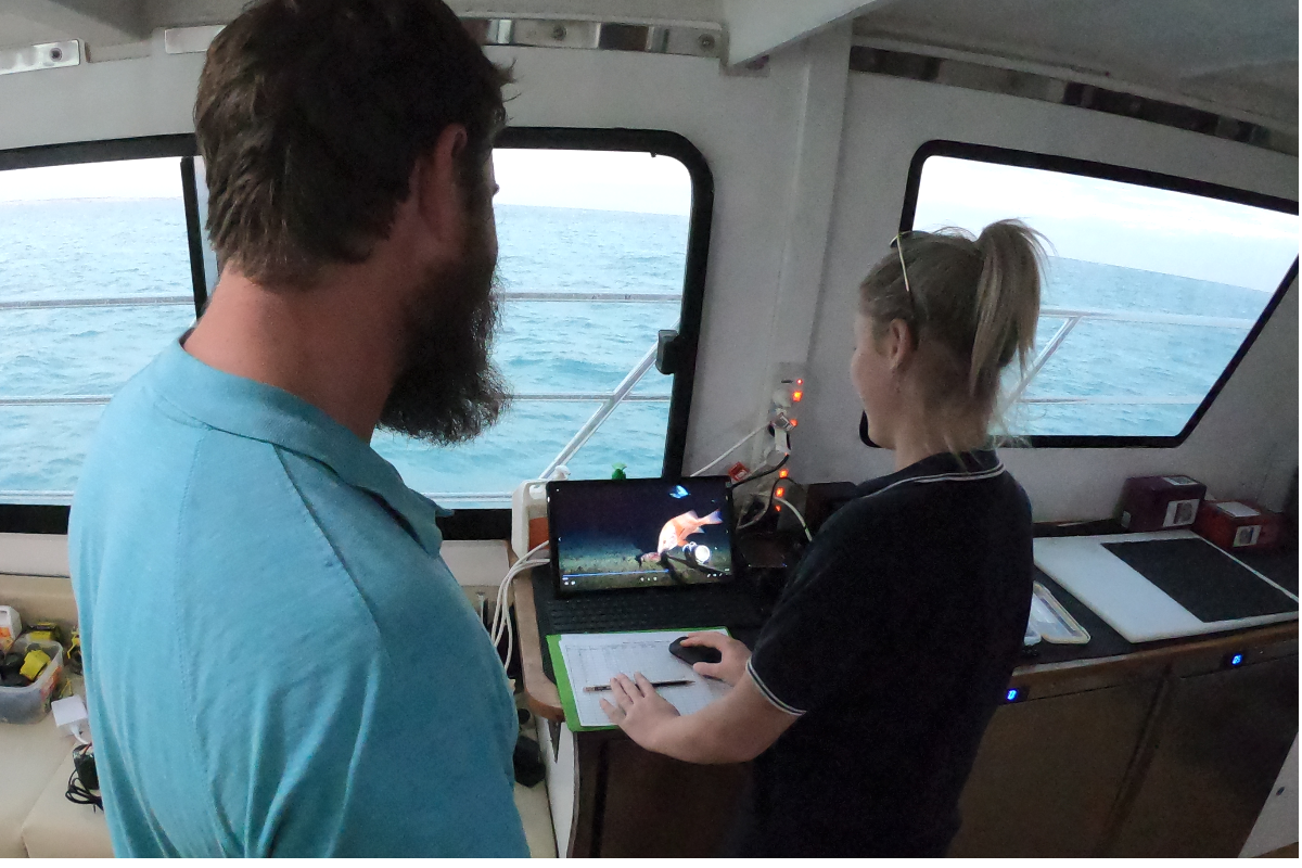 Researchers on a vessel review video recorded on the seafloor